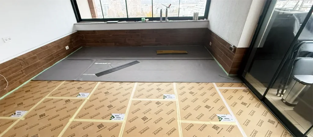 Multilayer soundproofing system installation on a wall showing insulation layers and measuring tools for effective soundproofing selection